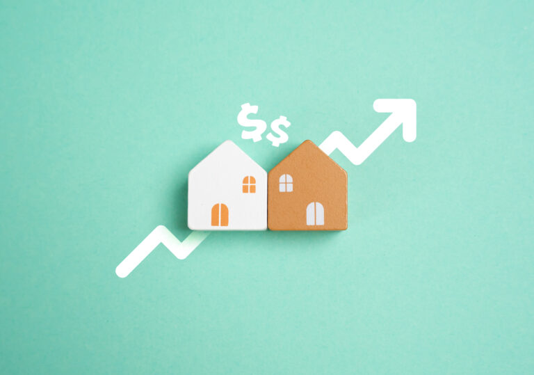 Two small house models on a green background with dollar signs and an upward arrow, symbolizing rising home prices or the Best Time to Buy a Home in St. Cloud Florida as the real estate market grows.